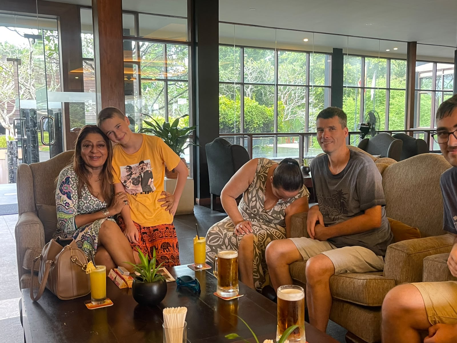 Family relaxing with fresh juice in a hotel lounge with their host